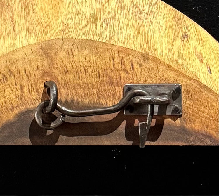 steel gate latch including stable, latch, catch with back mounting plate with four square lag bolts mounted to a slice of koa wood. example of CBA/ABANA Level 1 final project
